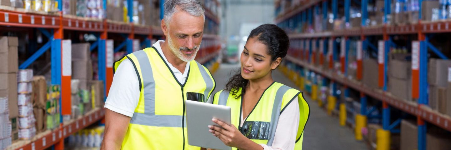 Warehouse workers discussing with digital tablet