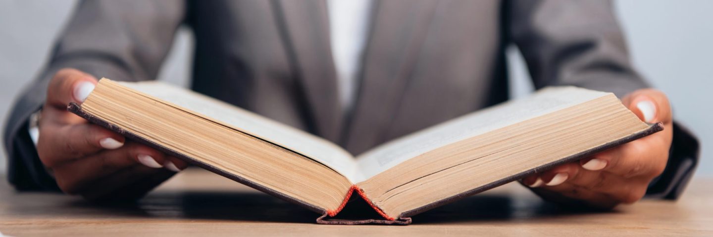 horizontal crop of lawyer holding book in office