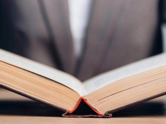 horizontal crop of lawyer holding book in office