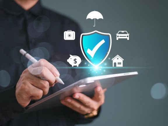 Insurance online agent concept, life solution, family, health, and financial technology. Businessman use tablet write insurance and assurance icon, real estate, car and finance for risk management.
