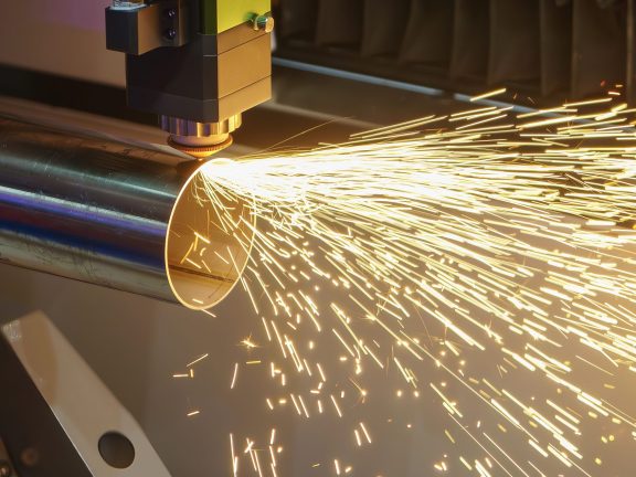 Close up scene the fiber laser cutting machine cut the stainless steel tube and sparkling light. The hi-technology sheet metal manufacturing process by laser cutting machine.